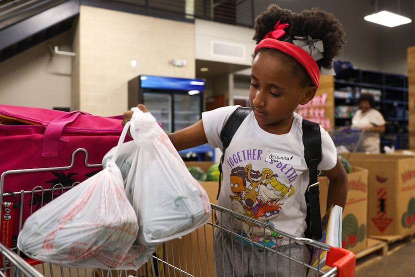 Dallas resident Blake Mason, 8, puts bagged green bell peppers into the cart during Brother...