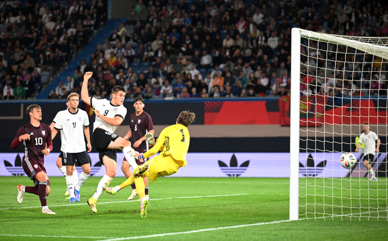 ROSTOCK, GERMANY - SEPTEMBER 09: Nicolo Tresoldi of Germany scores his team's fourth goal past Nikita Parfjonovs of Latvia during the 2025 UEFA European Under-21 Championship Qualifier match between Germany U21 and Latvia U21 at Ostseestadion on September 09, 2025 in Rostock, Germany. (Photo by Stuart Franklin/Getty Images)