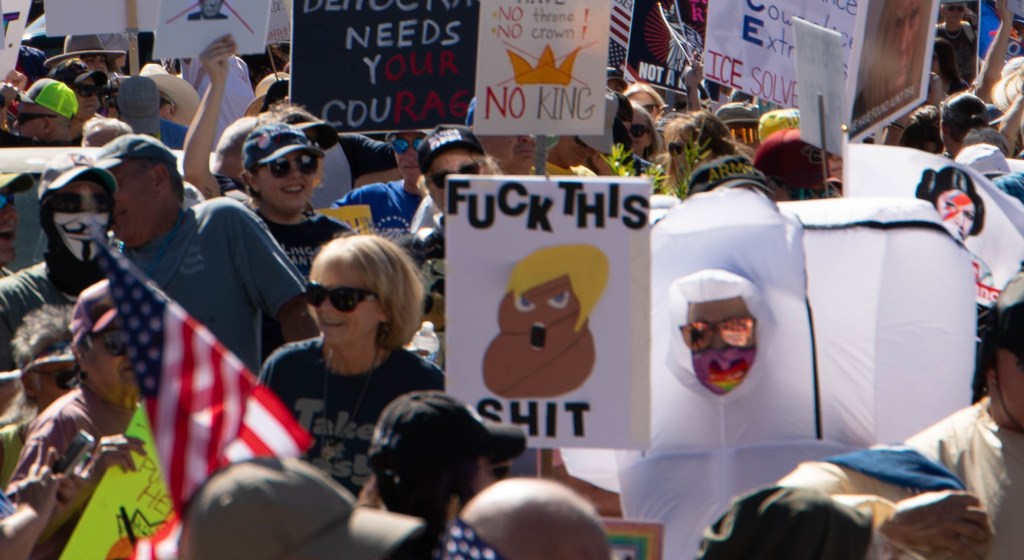 protesters hold signs at a anti-trump protest