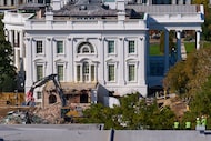 Construction workers (bottom right) atop the U.S. Treasury watch as work continues on a...