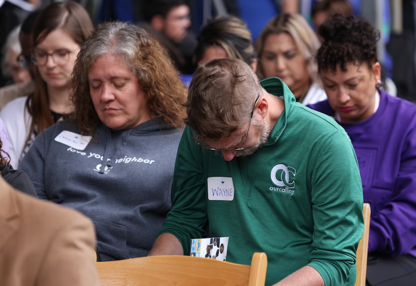 Guests bow their heads during a prayer as The Stewpot held its 50th birthday celebration at...