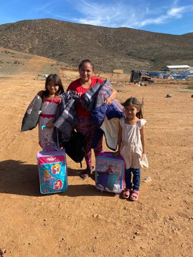 A family receiving assistance with blankets and more. (Bernardo Salado...