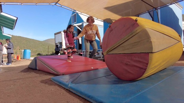 Sue Fasino with a child on a cylinder mat. (Bradley...