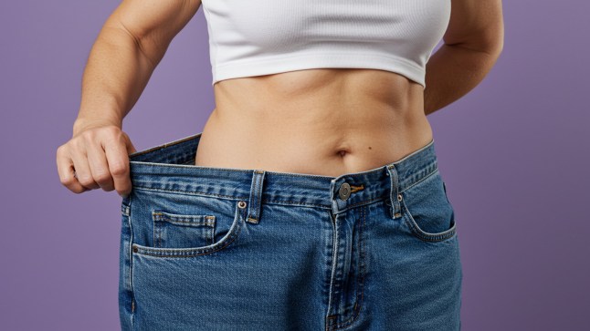 Image of someone showing their body in a larger pair of jeans