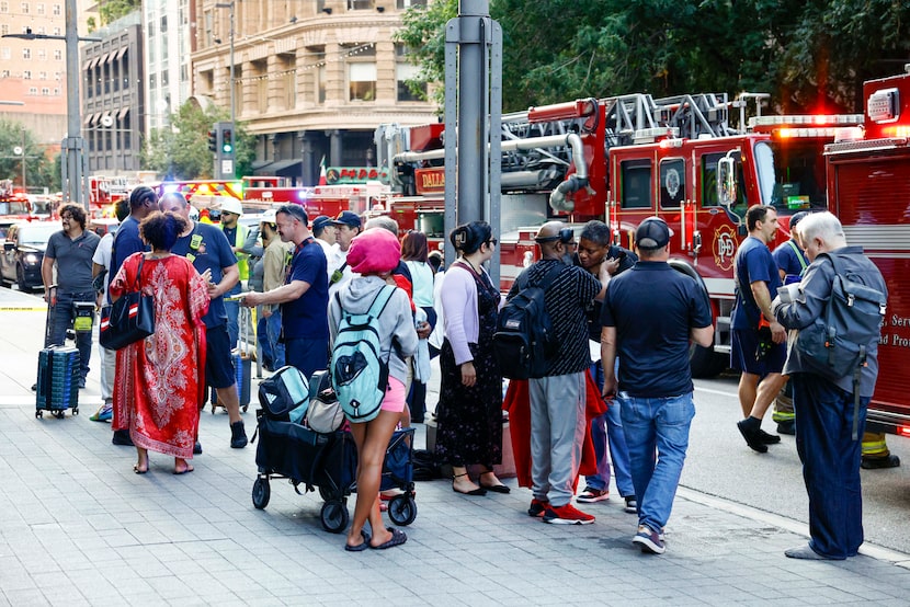 Residents gather outside Mercantile Place as Dallas Fire-Rescue respond to a call for...
