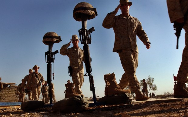 On the Fourth of July, 2004, Marines from the 2nd Battalion, 1st Marines Regiment at Camp Baharia walk past a memorial and render a salute honoring two Marines who died in Fullujah, Iraq. (Nelvin C. Cepeda / The San Diego Union-Tribune)