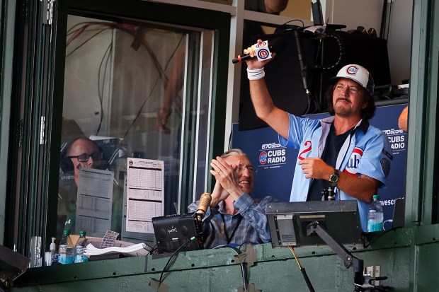 Eddie Vedder gestures to the crowd before performing during the seventh inning stretch during game one of the NL Wild Card Series between the Chicago Cubs and the San Diego Padres at Wrigley Field on Tuesday, Sept. 30, 2025 in Chicago, Illinois. (Meg McLaughlin / The San Diego Union-Tribune)