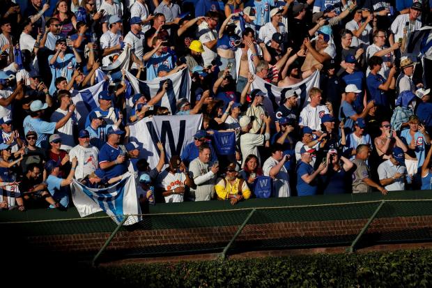 A trio of Padres fans, bottom center, look on as Cubs fans celebrate after game one of the NL Wild Card Series at Wrigley Field on Tuesday, Sept. 30, 2025 in Chicago, Illinois. (Meg McLaughlin / The San Diego Union-Tribune)