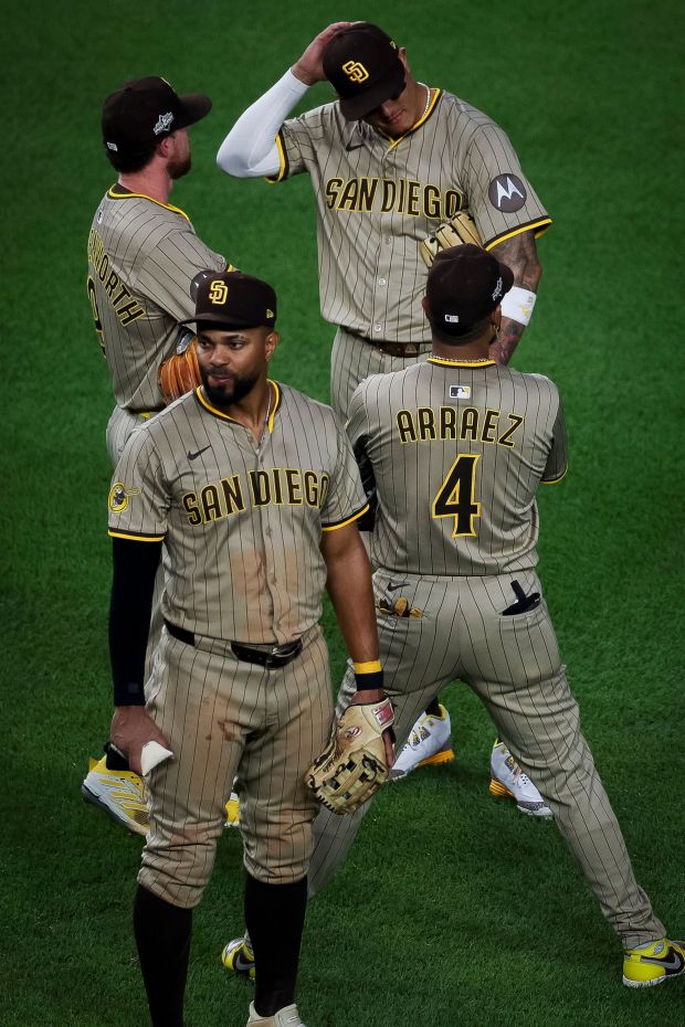 Jake Cronenworth #9, Manny Machado #13, Xander Bogaerts #2, and Luis Arraez #4 of the San Diego Padres look on during a pitching change in the seventh inning against the Chicago Cubs during Game 3 of the NL Wild Card Series at Wrigley Field on Thursday, Oct. 2, 2025 in Chicago, Illinois. (Meg McLaughlin / The San Diego Union-Tribune)