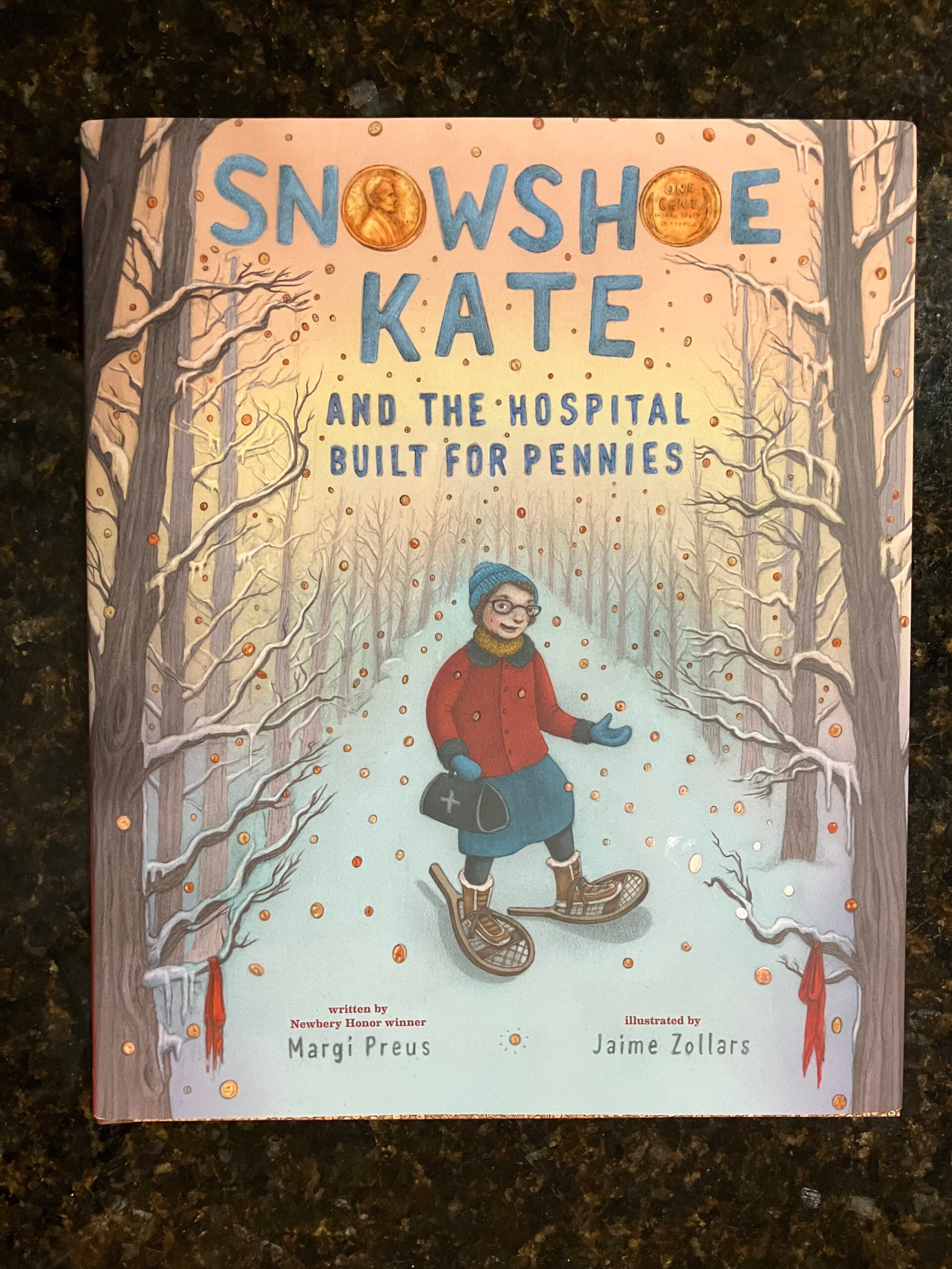 The cover of the book Snowshoe Kate and the Hospital Built for Pennies by Margi Preus, illustrated by Jaime Zollars, shows a woman in snowshoes walking in a snowy forest.