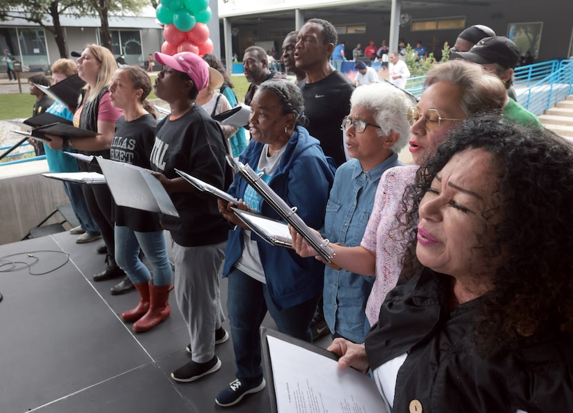 Members of the Dallas Street Choir combine their voices and raise them in song as The...