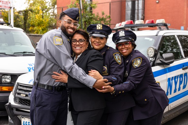 Retired Detective Marilyn Ozuna, 62, center left, with three of her four children PPO Anthony Philips, 24, left, PO Marilyn G. Ozuna, 34, right, and Detective Rose Martinez, 43, center right, outside of the 81st Pct. in Brooklyn, Tuesday, Oct. 14, 2025. (Shawn Inglima/ New York Daily News)