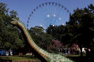 A giant dinosaur structure emerges from the waters of the Lagoon at Fair Park as The Star...