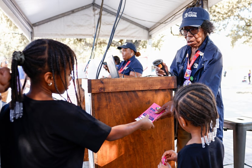 State Fair of Texas employee Faye Thomas, 87, scans a ticket for a young fairgoer at an...