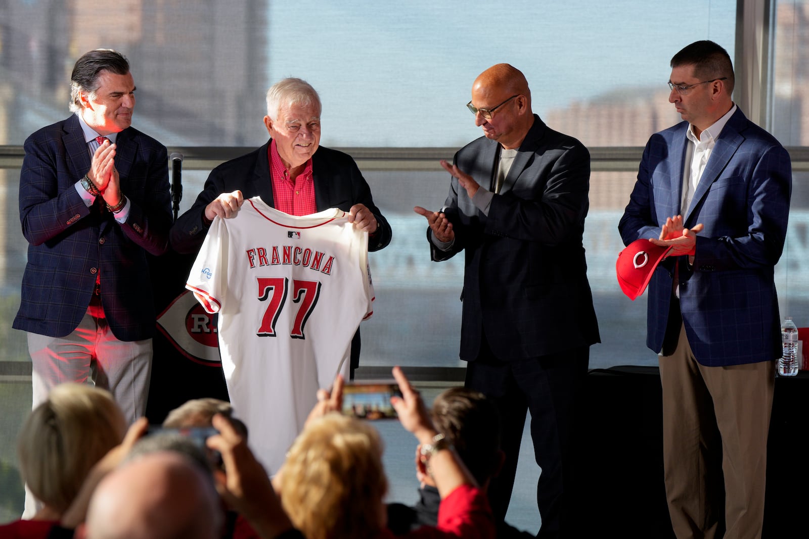 Cincinnati Reds owner Bob Castellini presents new manager Terry Francona with a jersey as COO Phil Castellini, far left, and president of baseball operations Nick Krall, far right, look on during an introductory press conference Monday, Oct. 7, 2024, in Cincinnati. (AP Photo/Jeff Dean)