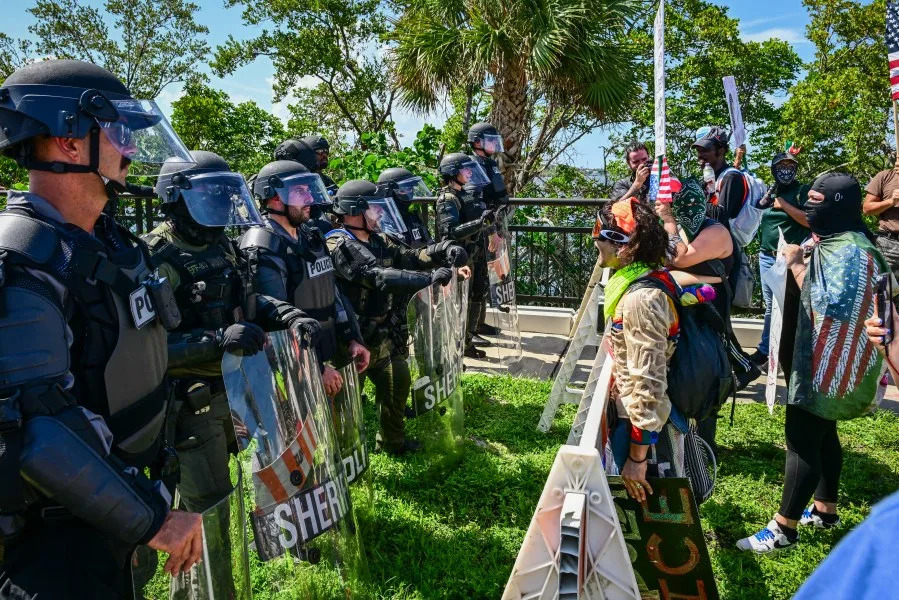 Demonstrators confront the police as they protest against the Trump administration during the “No Kings” rally near US President Donald Trump’s Mar-a-Lago home in West Palm Beach, Florida, on June 14, 2025. In response to the military parade celebrating the 250th anniversary of the US Army but also coinciding with Trump’s 79th birthday, a “No Kings” movement has sprung up promising to stage protests in more than 2,000 places across the country, including a large parade expected in Los Angeles which organizers say will feature a “20-foot-tall balloon of Trump wearing a diaper.” (Photo by Giorgio Viera / AFP) (Photo by GIORGIO VIERA/AFP via Getty Images)