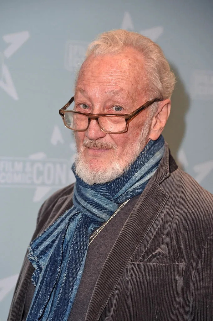 Man with glasses in a corduroy jacket and scarf, attending a film and comic event