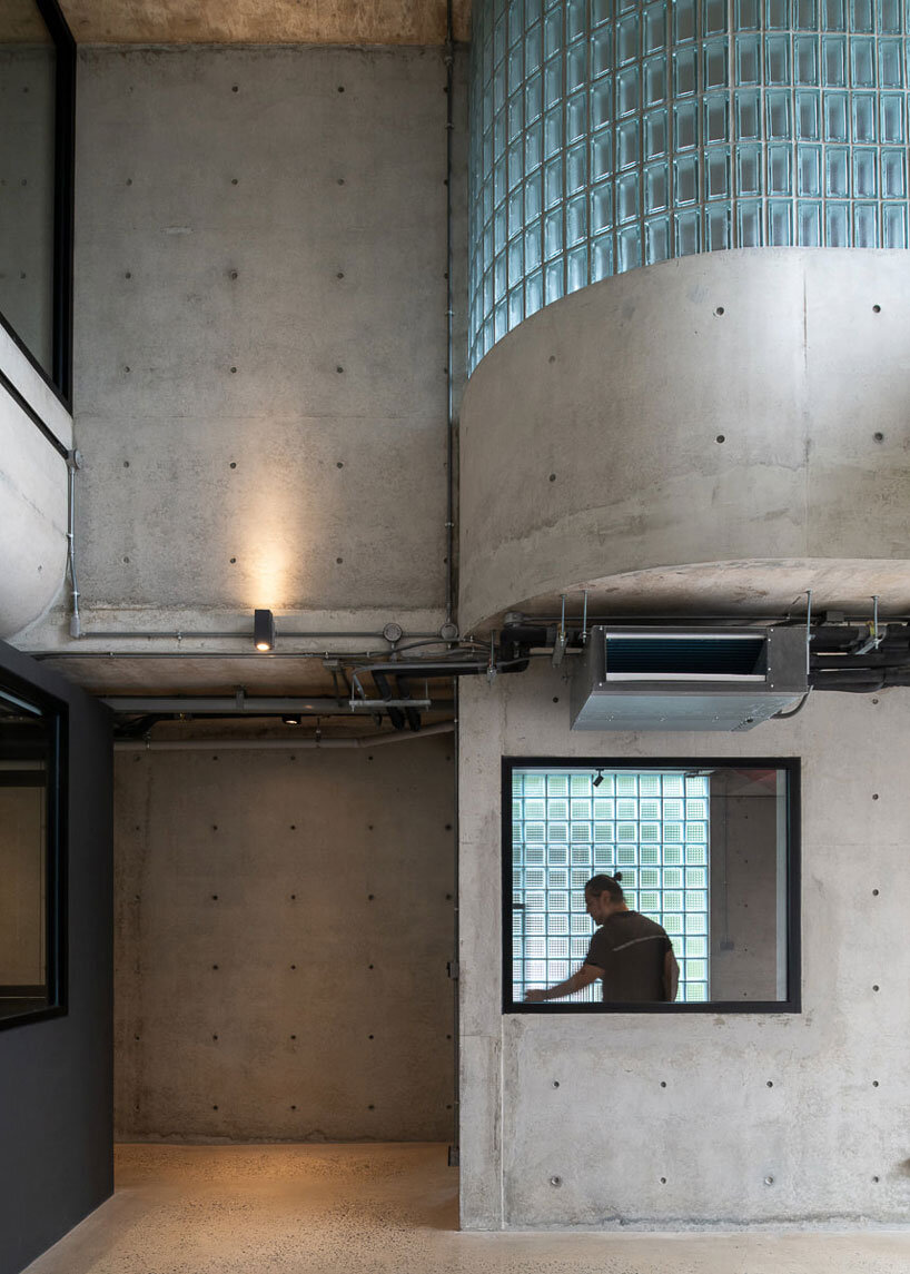 green courtyard anchors hybrid home and office within concrete structure in bangkok