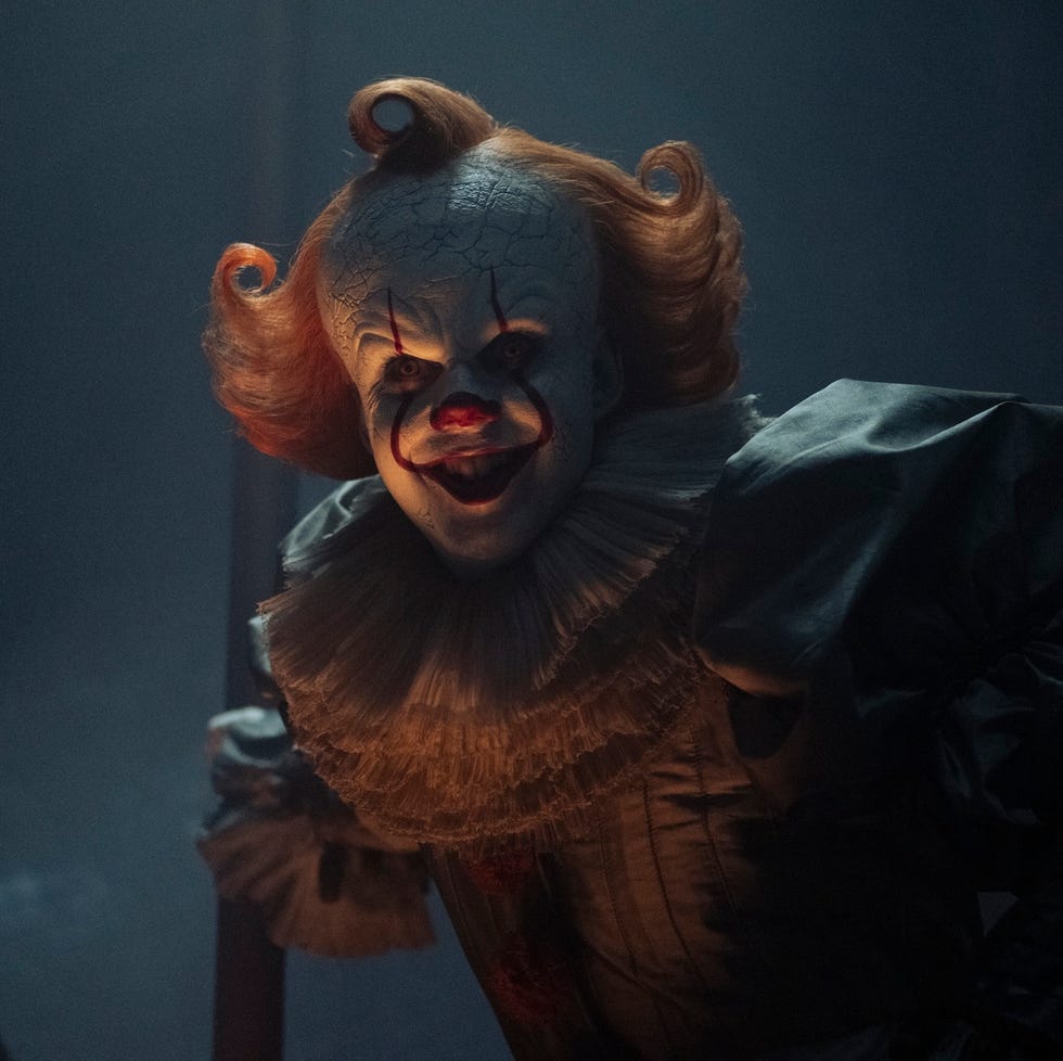 a haunting figure dressed as a clown with a ruffled collar holding a stick and posing dramatically