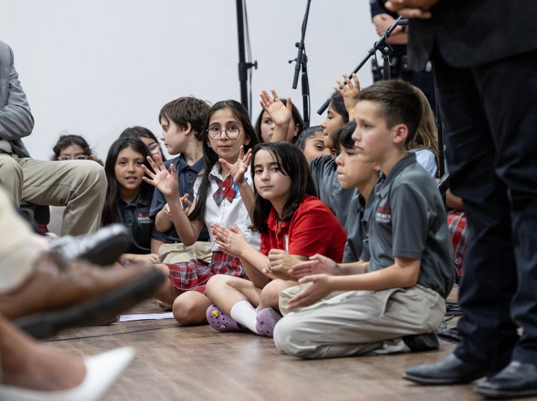 Students at St. Mary Magdalen Catholic School applaud for Gov. Greg Abbott Thursday.