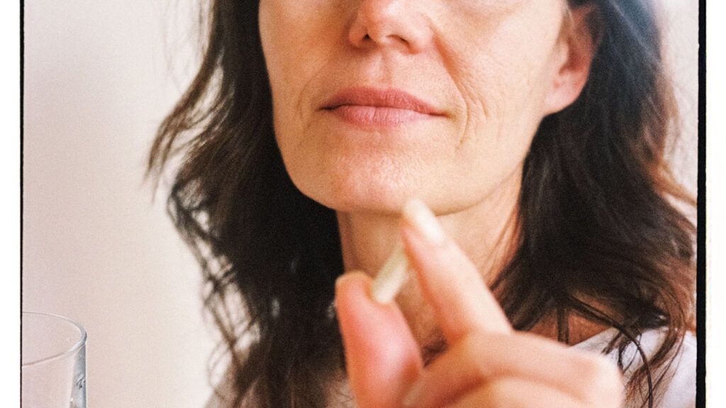 older white woman holding calcium supplement pill