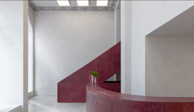 parabolic structures painted in burgundy stucco outline stockholm eyewear flagship