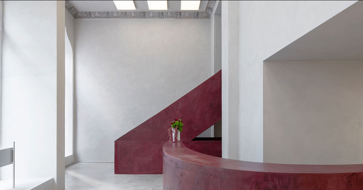 parabolic structures painted in burgundy stucco outline stockholm eyewear flagship
