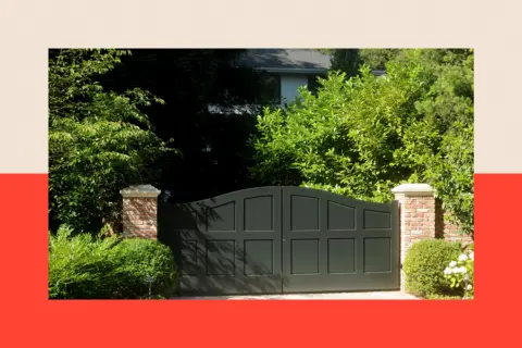 Bloomberg via Getty Images Large gate and green bushes with a house in shadows in the background