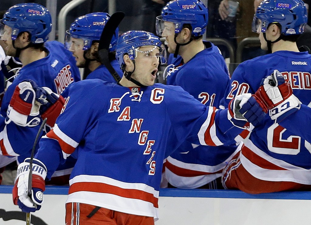 Ryan Callahan in a blue Rangers jersey celebrating a goal with teammates.