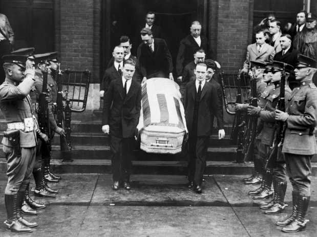 Pall bearers carry the body of Edwin C. Shanahan, who was shot and killed by Martin Durkin, from St. Leo's Catholic Church at 78th street and Emerald Avenue, while a guard of honor from the 14th cavalry stands at attention on Oct. 14, 1925. (Chicago Tribune historical photo)