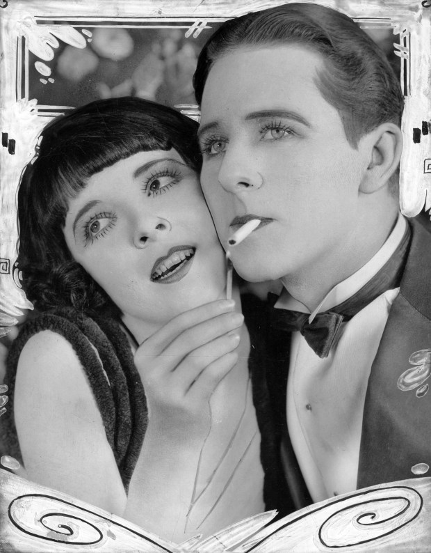 Colleen Moore as Patricia Frentiss and Ben Lyons as as Monty Standish in "Flaming Youth" in 1923. The film was produced by Moore's husband, John McCormick. Editors note: this historic print shows illustration designs around the edges. (Associated First National)
