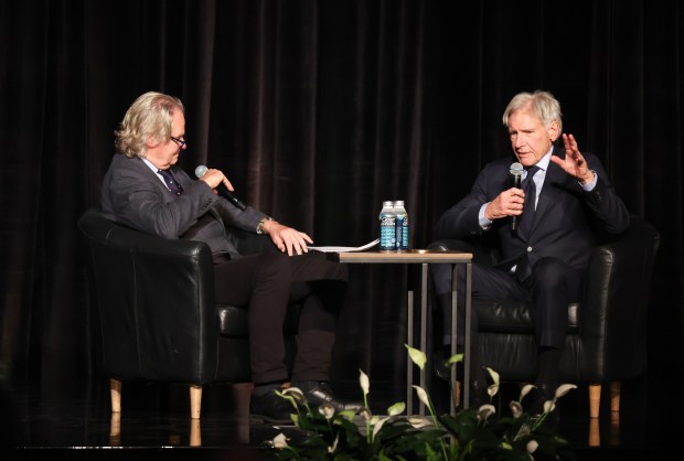 Harrison Ford speaks with anthropology professor Wade Davis after accepting the E.O. Wilson Legacy Award for Transformative Conservation Leadership at the Field Museum on Oct. 29, 2025. (Talia Sprague/for the Chicago Tribune)