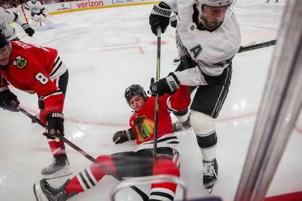 Los Angeles Kings center Phillip Danault (24) pushes Chicago Blackhawks center Frank Nazar (91) onto the ice during the first period at the United Center Sunday Oct. 26, 2025 in Chicago. (Armando L. Sanchez/Chicago Tribune)