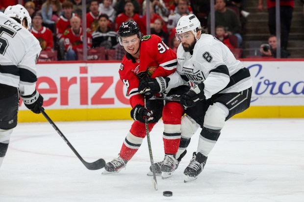 Chicago Blackhawks center Connor Bedard (98) passes the puck while being guarded by Los Angeles Kings defenseman Drew Doughty (8) during the first period at the United Center Sunday Oct. 26, 2025 in Chicago. (Armando L. Sanchez/Chicago Tribune)