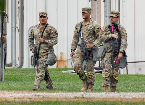 Members of the Texas National Guard walk around the Army...