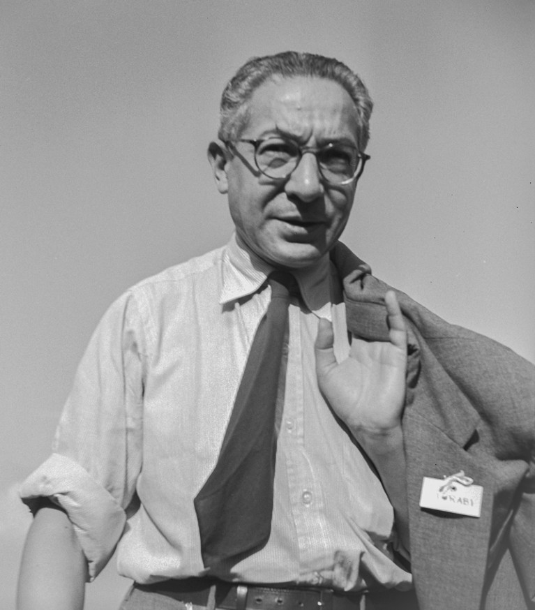Black and white photograph of Isidor Rabi carrying his jacket over his shoulder.