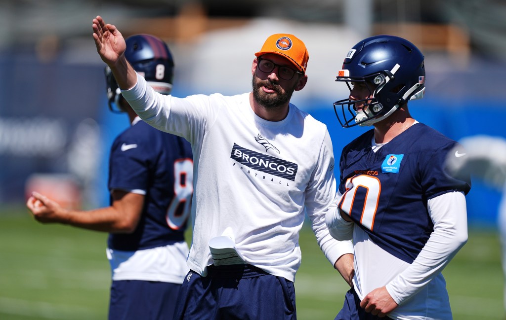 Denver Broncos quarterbacks coach Davis Webb directs quarterback Bo Nix during practice.