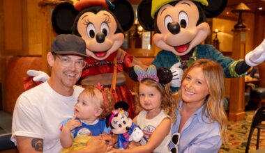 A happy family with two children poses with Mickey and Minnie Mouse at a Disney park restaurant, not far from Cinderella Castle.