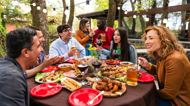 a group of friends eat around a table
