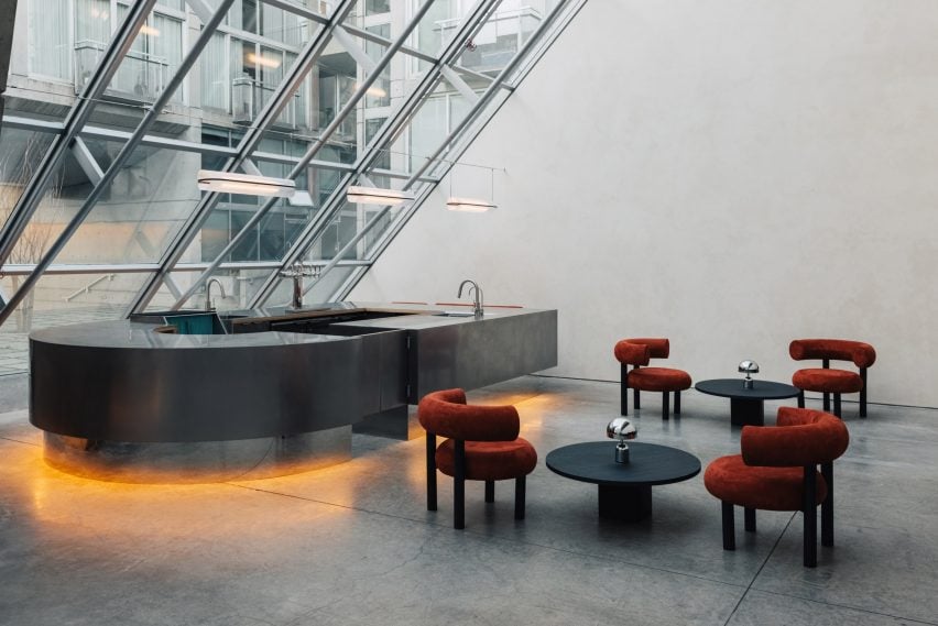 Lights installed underneath brushed stainless steel bar counters reflect in the polished concrete floor