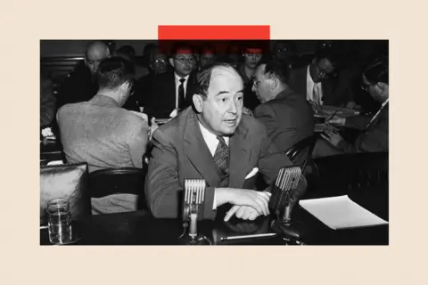 Getty Images Black and white image of John von Neumann wearing a suit and sitting at a table