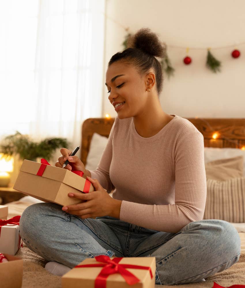 People Are Making These Sacrifices to Save Money This Holiday Season woman wrapping gifts for holidays