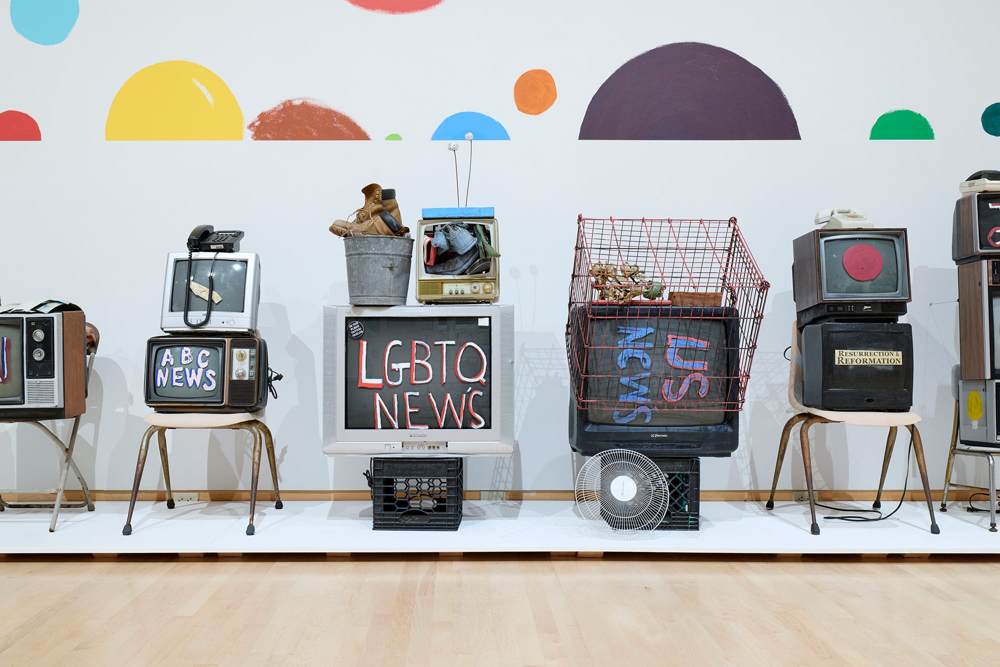 an installation of painted tv sets by Tyree Guyton against polka dotted walls
