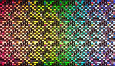 Rainbow colored iridescent semiconductor wafer extreme close-up studio shot.