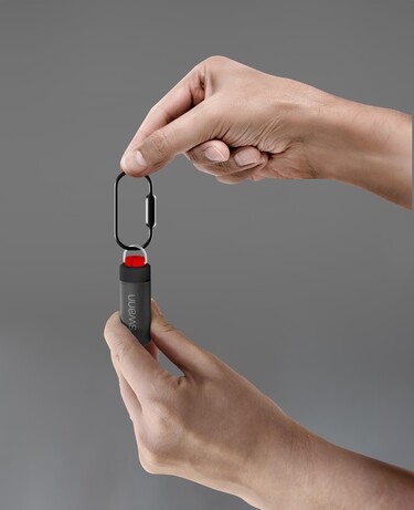 Swann Active Response Personal Alarm being held on a grey background