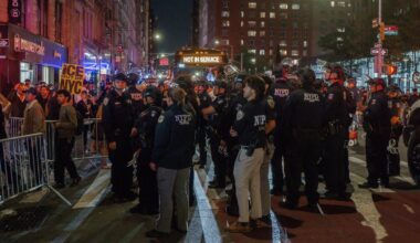 Dozens of police officers stand in the road during a protest against immigration crackdown in the aftermath of a raid on Tuesday, Oct. 21, 2025, in New York. (AP Photo/Olga Fedorova)