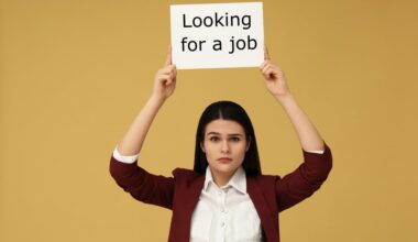 A young woman holds a sign that reads 'Looking for a job'