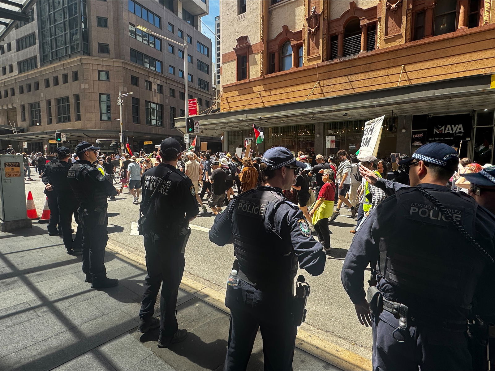Police look on at protesters walking the streets