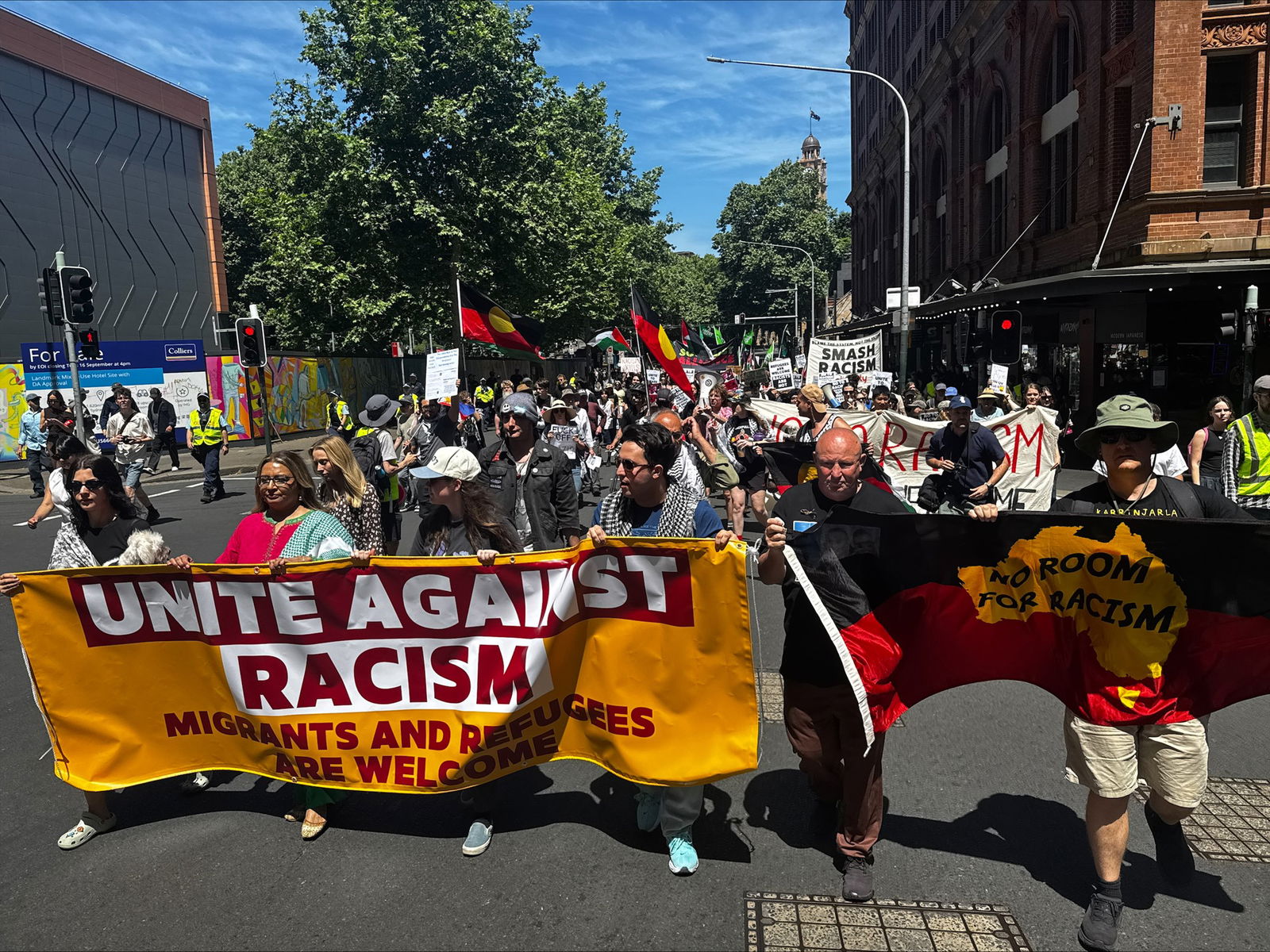 People of walking behind a "unite against racism" banner