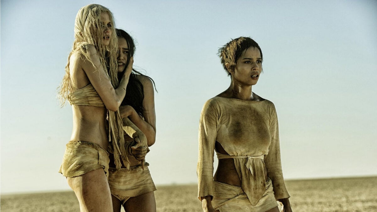 Scantly clad women in Mad Max: Fury Road stare out at something beyond the camera.